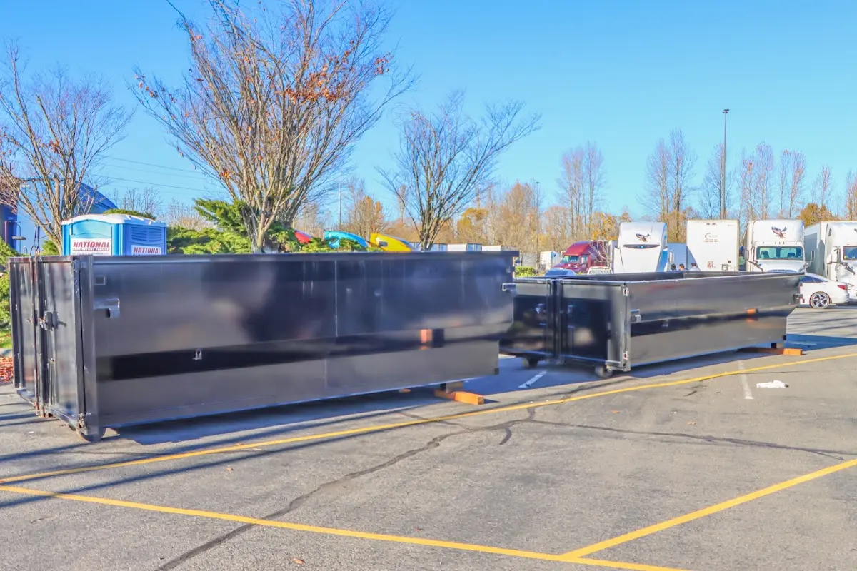 Professional dumpster rental service with roll-off container on residential driveway in Baldwin